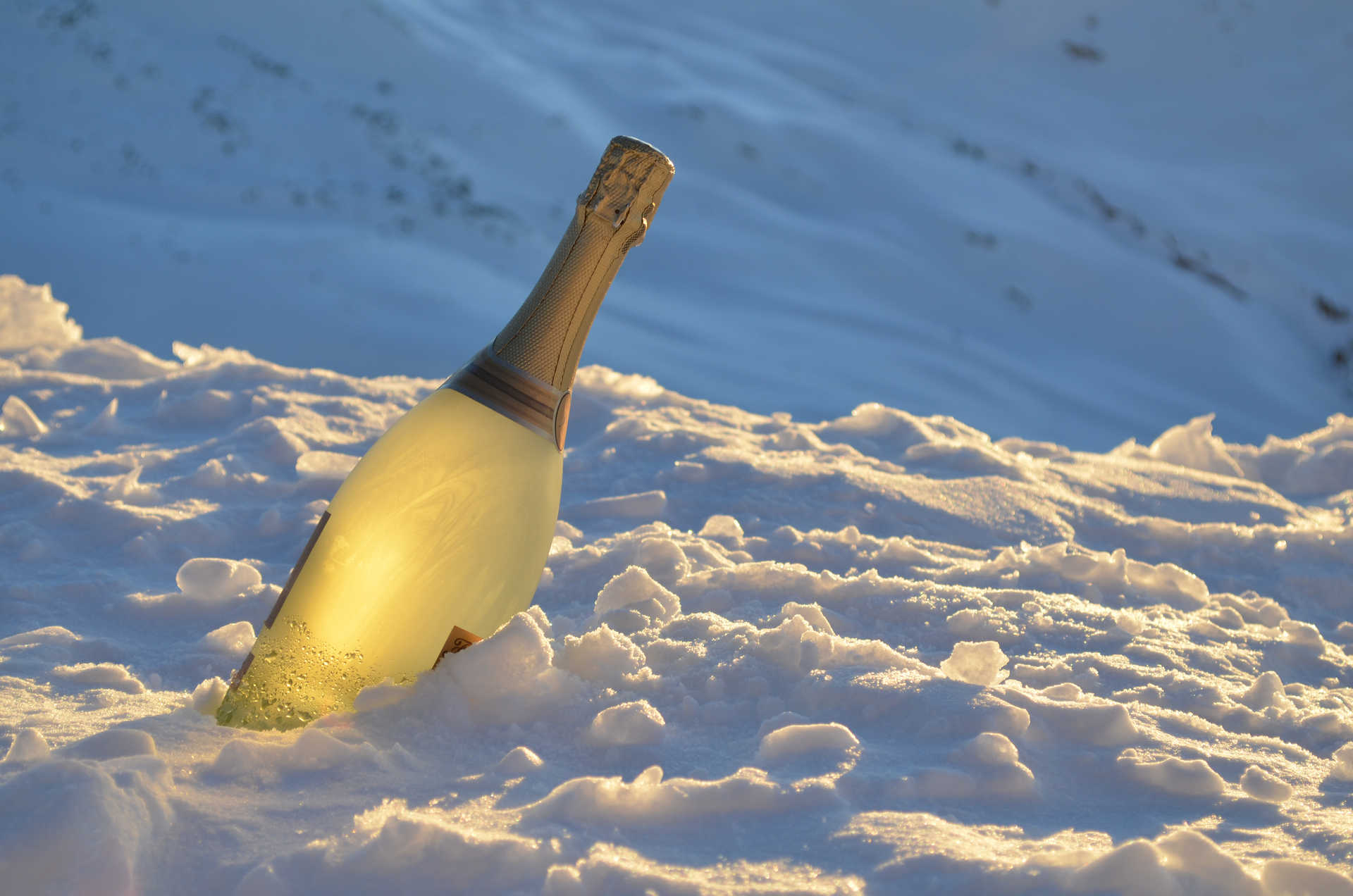 botella de champán enfriándose en la nieve 